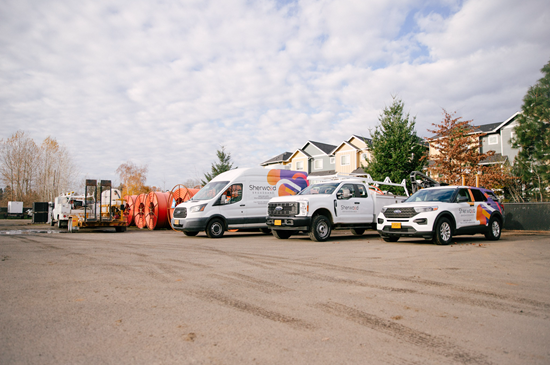 Sherwood Broadband vehicles in a lot next to spools of fiber