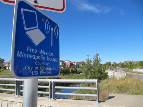 A blue sign reads: "Free Wireless hotspot Minneapolis"