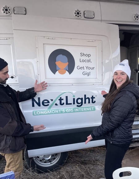 Longmont NextLight Shop local truck Two happy subscribers point at NextLight truck that urges shop local
