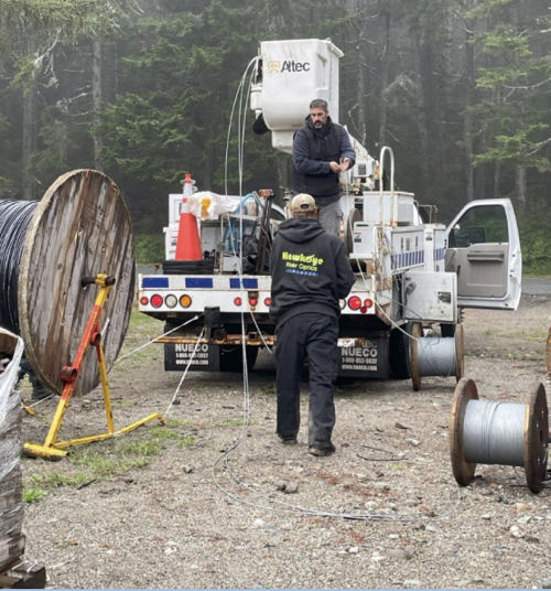 Isle au Haut fiber deployment A crew of two workers at back of work truck getting ready to deploy fiber strands