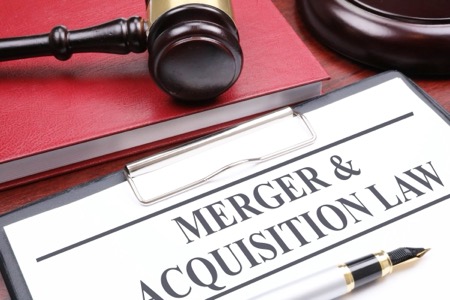 Merger and Acquisition paperwork on desk next to gavel