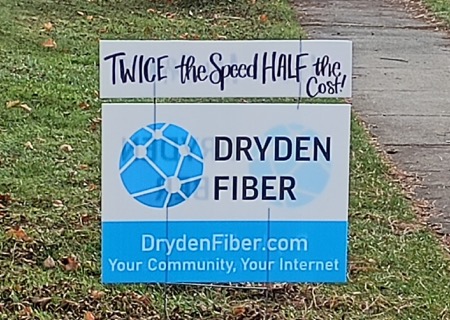 A yard sign reads: "Twice the Speed, Half the Cost. Dryden Fiber"