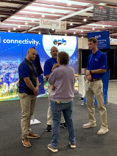 Three EPB employees listening intently to a EPB subscriber at a local home show