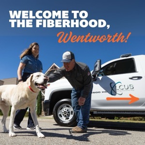 A LCUB employee pets a dog in the presence of its owner next to a LCUB truck. The ad says "Welcome to the Fiberhood, Wentworth!"