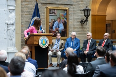 NRECA members sit next to podium at Rural Electrification Act commemoration looking stoned-faced 